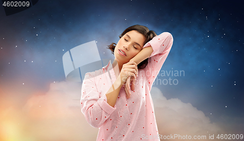 Image of tired woman in pajama napping over night sky