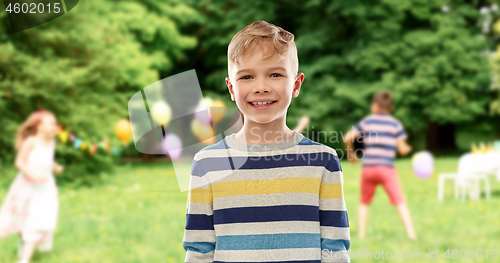 Image of smiling boy at birthday party in summer park