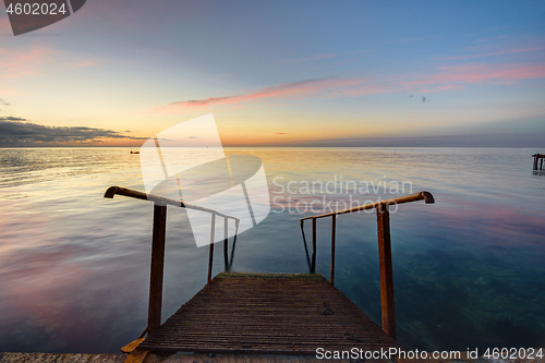 Image of The old mittal staircase on the pier descends into the sea, against the background of the evening beautiful sunset