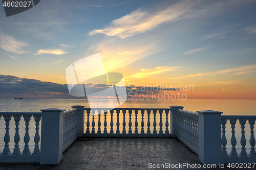 Image of Beautiful building with columns on a landscaped promenade at sunset