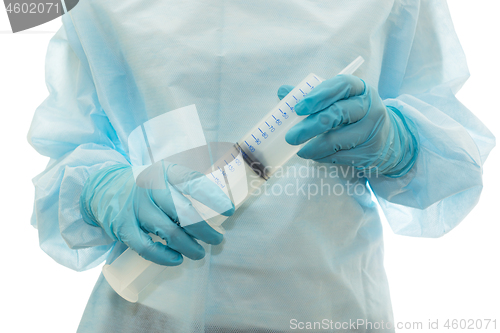 Image of Hands of medic in sterile gown and gloves hold big syringe, isolated