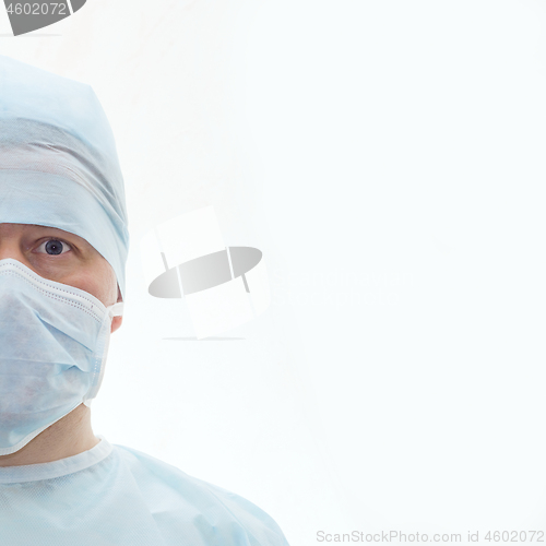 Image of Half face of surgeon in sterile surgical mask and medical cap isolated on white