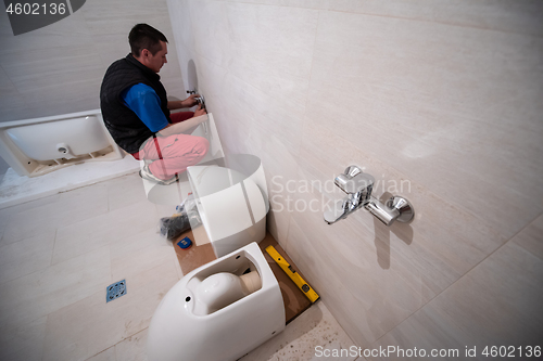 Image of professional plumber working in a bathroom