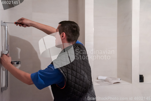 Image of professional plumber working in a bathroom