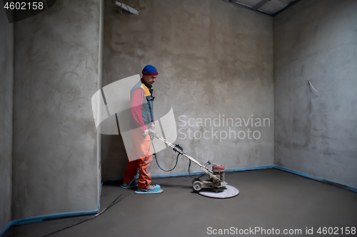 Image of worker performing and polishing sand and cement screed floor