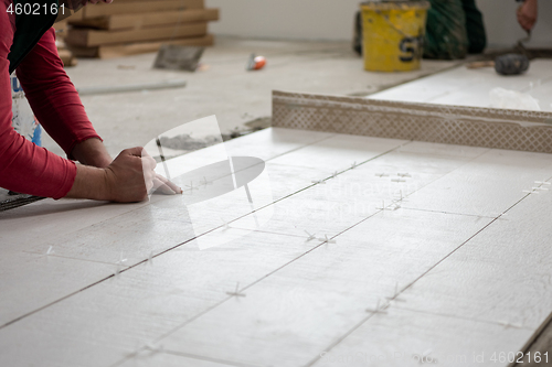 Image of worker installing the ceramic wood effect tiles on the floor