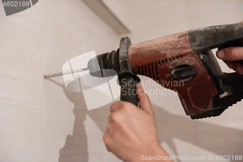 Image of construction worker drilling holes in the bathroom