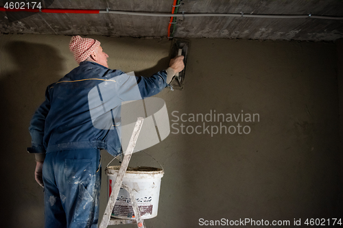 Image of Worker plastering the wall by concrete