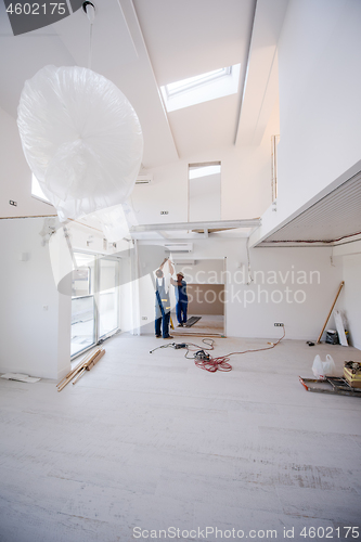 Image of carpenters installing glass door with a wooden frame