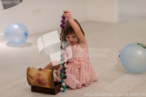 Image of little girl enjoying while playing with mother\'s jewelry
