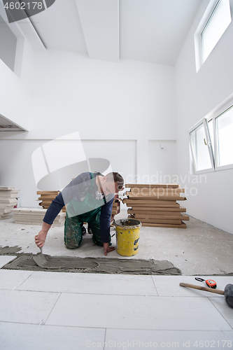 Image of worker installing the ceramic wood effect tiles on the floor