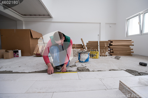 Image of worker installing the ceramic wood effect tiles on the floor