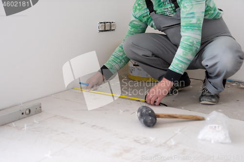 Image of worker installing the ceramic wood effect tiles on the floor