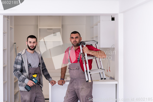 Image of young workers installing a new kitchen