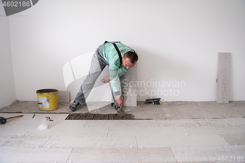 Image of worker installing the ceramic wood effect tiles on the floor