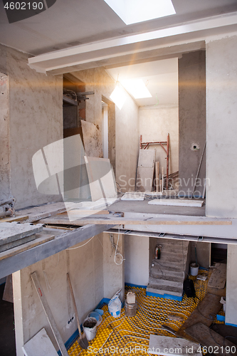 Image of yellow underfloor heating installation with white pipes