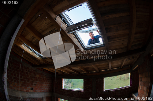 Image of construction worker installing roof window