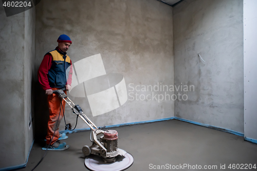 Image of worker performing and polishing sand and cement screed floor