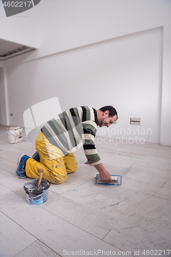 Image of Tilers filling the space between ceramic wood effect tiles