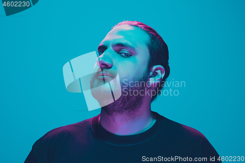 Image of Portrait of a guy with colorful neon light on blue background - cyberpunk concept