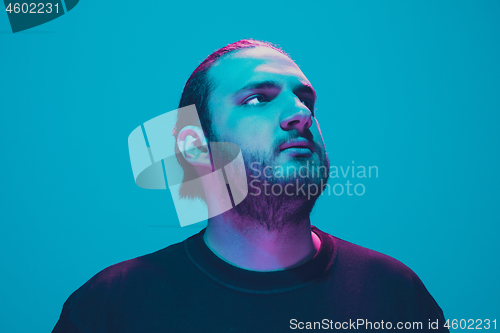 Image of Portrait of a guy with colorful neon light on blue background - cyberpunk concept