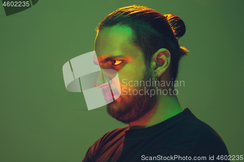 Image of Portrait of a guy with colorful neon light on green background - cyberpunk concept