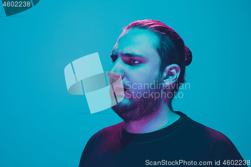 Image of Portrait of a guy with colorful neon light on blue background - cyberpunk concept