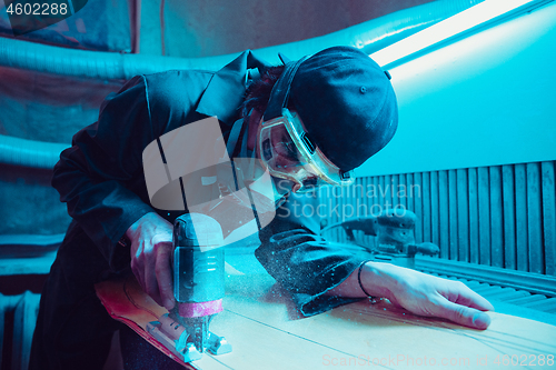 Image of Skater in process of making his own skateboard, longboard - open business concept