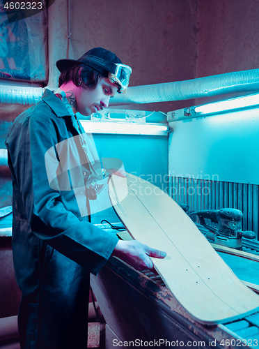 Image of Skater in process of making his own skateboard, longboard - open business concept