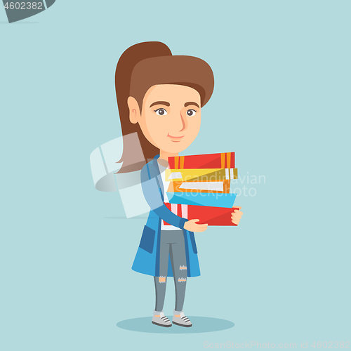 Image of Young caucasian student holding pile of books.