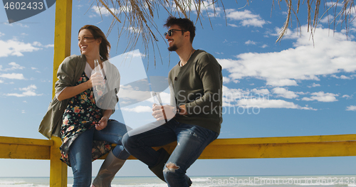 Image of Group of friends having fun on autumn day at beach