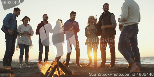 Image of Friends having fun at beach on autumn day