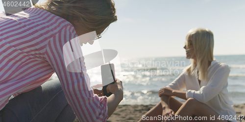 Image of Two girl friends having fun photographing each other on vecation