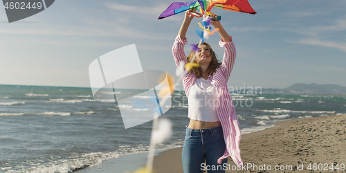 Image of Happy couple having fun with kite on beach