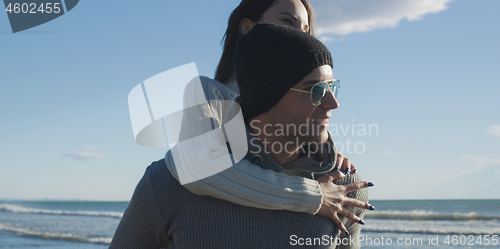 Image of couple having fun at beach during autumn