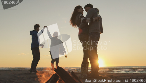 Image of Friends having fun at beach on autumn day