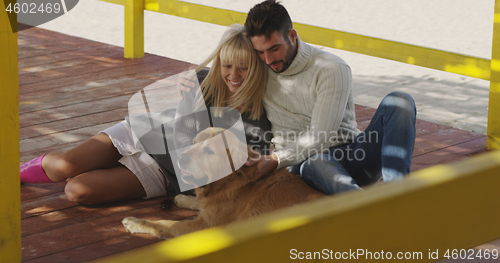 Image of Couple with dog enjoying time on beach