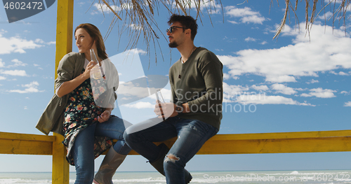 Image of Group of friends having fun on autumn day at beach