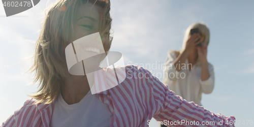 Image of Two girl friends having fun photographing each other on vecation