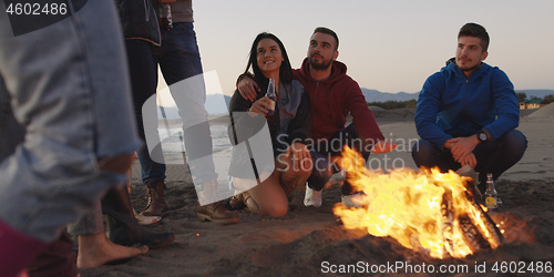 Image of Friends having fun at beach on autumn day