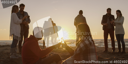 Image of Friends having fun at beach on autumn day