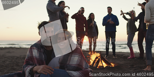 Image of Friends having fun at beach on autumn day