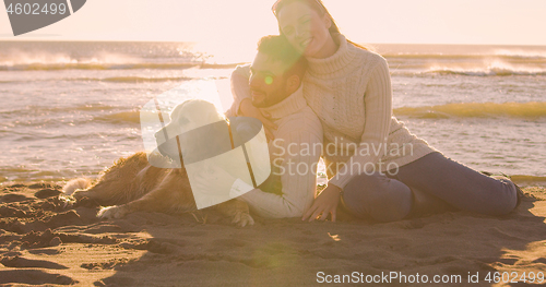 Image of Couple with dog enjoying time on beach