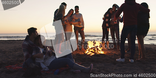 Image of Friends having fun at beach on autumn day