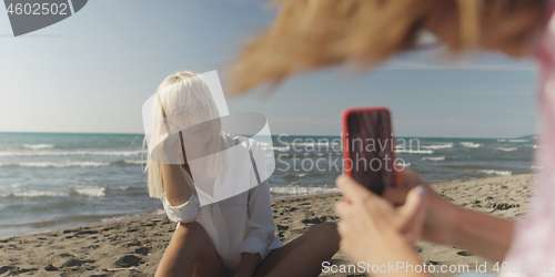 Image of Two girl friends having fun photographing each other on vecation