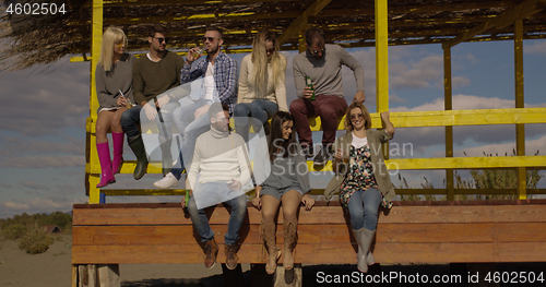 Image of Group of friends having fun on autumn day at beach