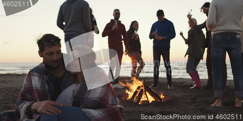 Image of Friends having fun at beach on autumn day