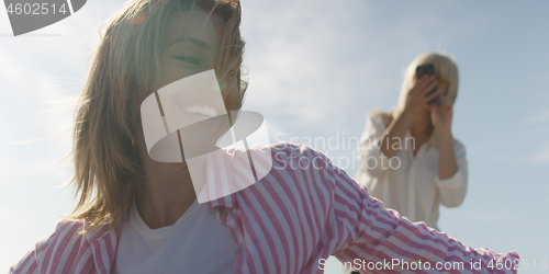 Image of Two girl friends having fun photographing each other on vecation