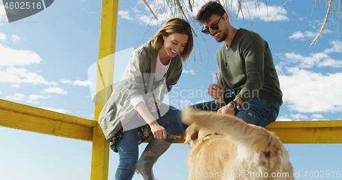 Image of Group of friends having fun on autumn day at beach