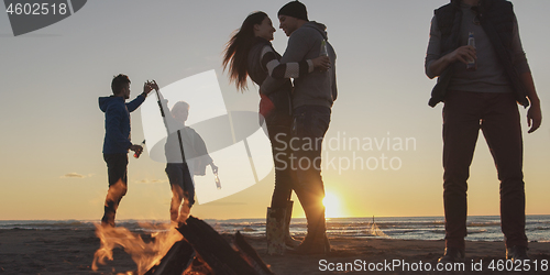 Image of Friends having fun at beach on autumn day